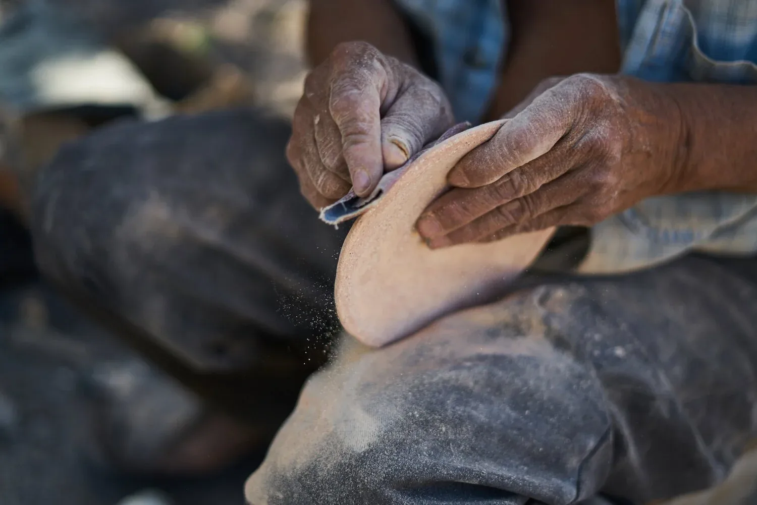 Weathered hands working clay at the Espadas Family pottery workshop in Uayma, Yucatán
