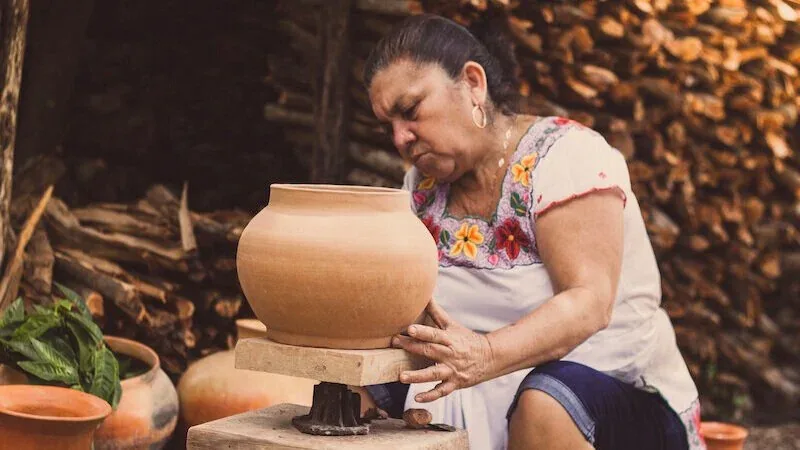 Potter turning a piece on a hand-driven wheel