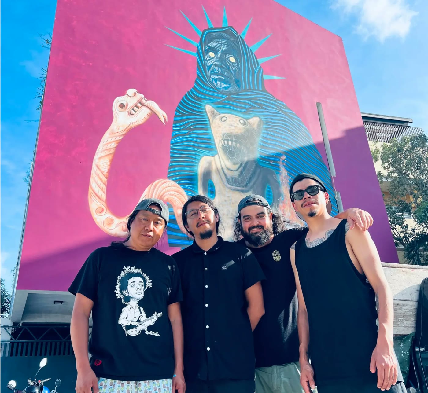 Four members of the Horizontes Mexicanos team standing together in front of a large pink mural in Tulum.